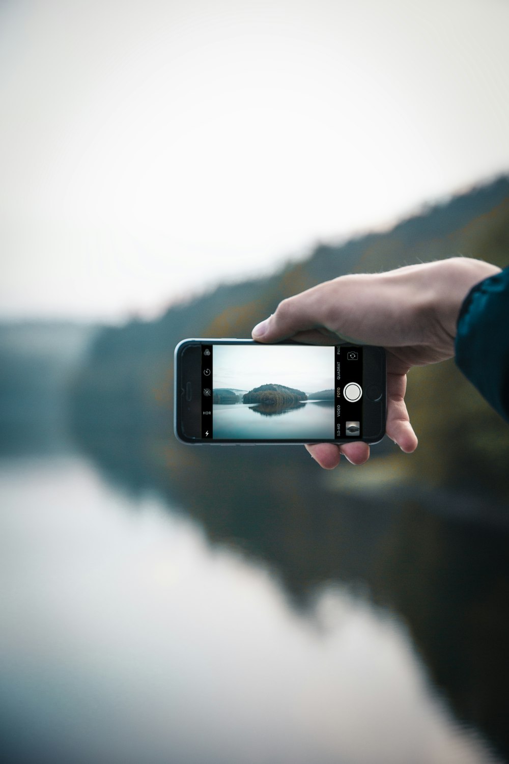 a person taking a picture with a cell phone