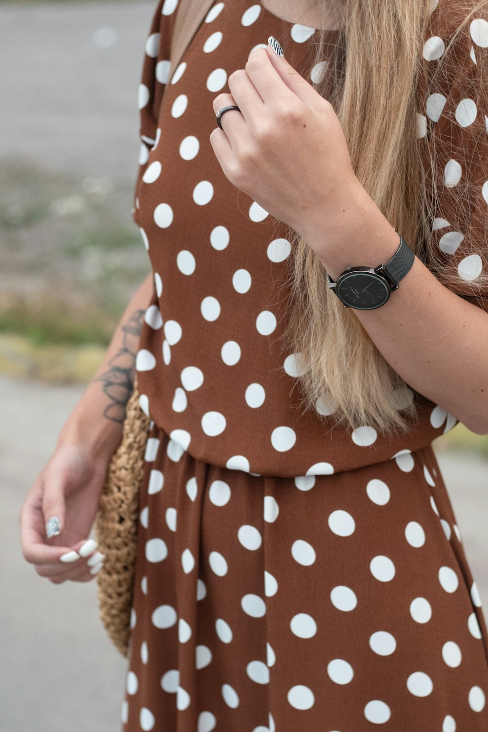 a woman wearing a brown and white polka dot dress