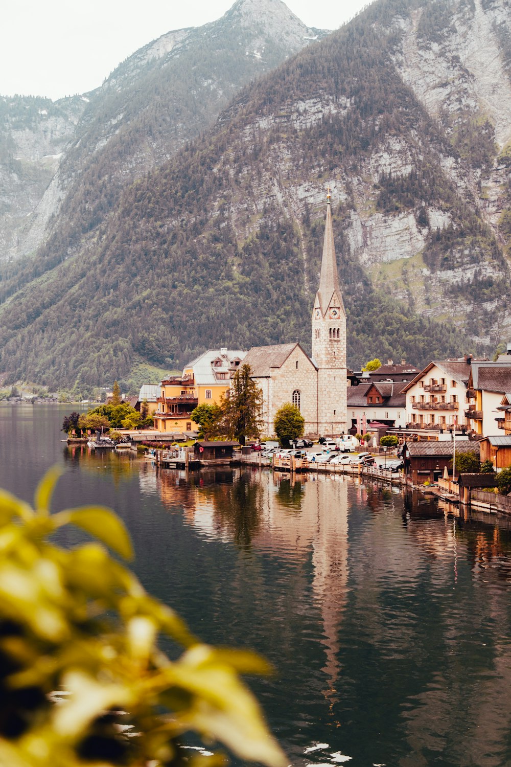 a small town on a lake with mountains in the background