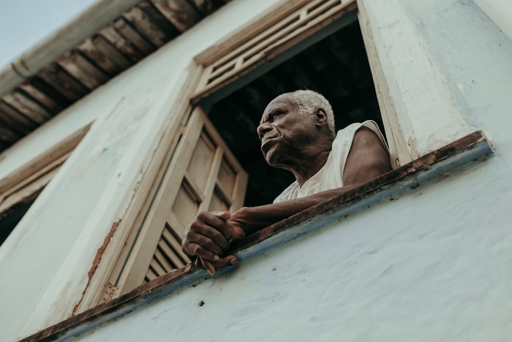 a man looking out of a window of a building