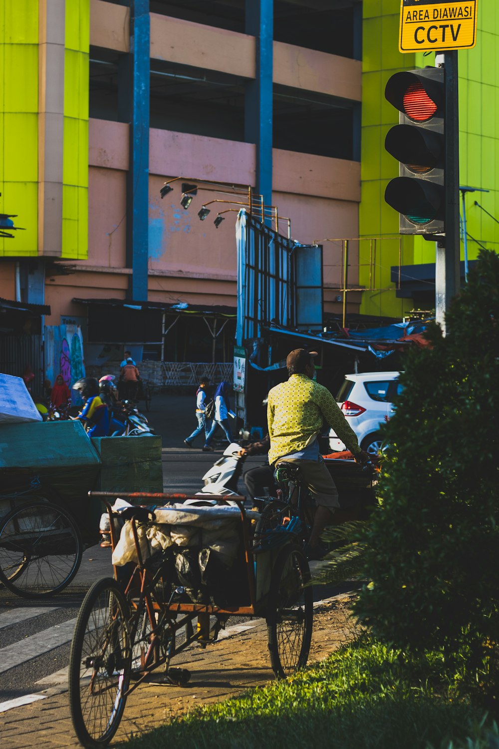 a man riding a bike down a street next to a traffic light