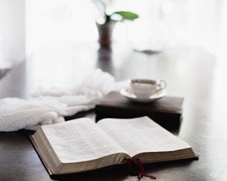A close-up of an open e-book on a wooden table with a coffee cup.
