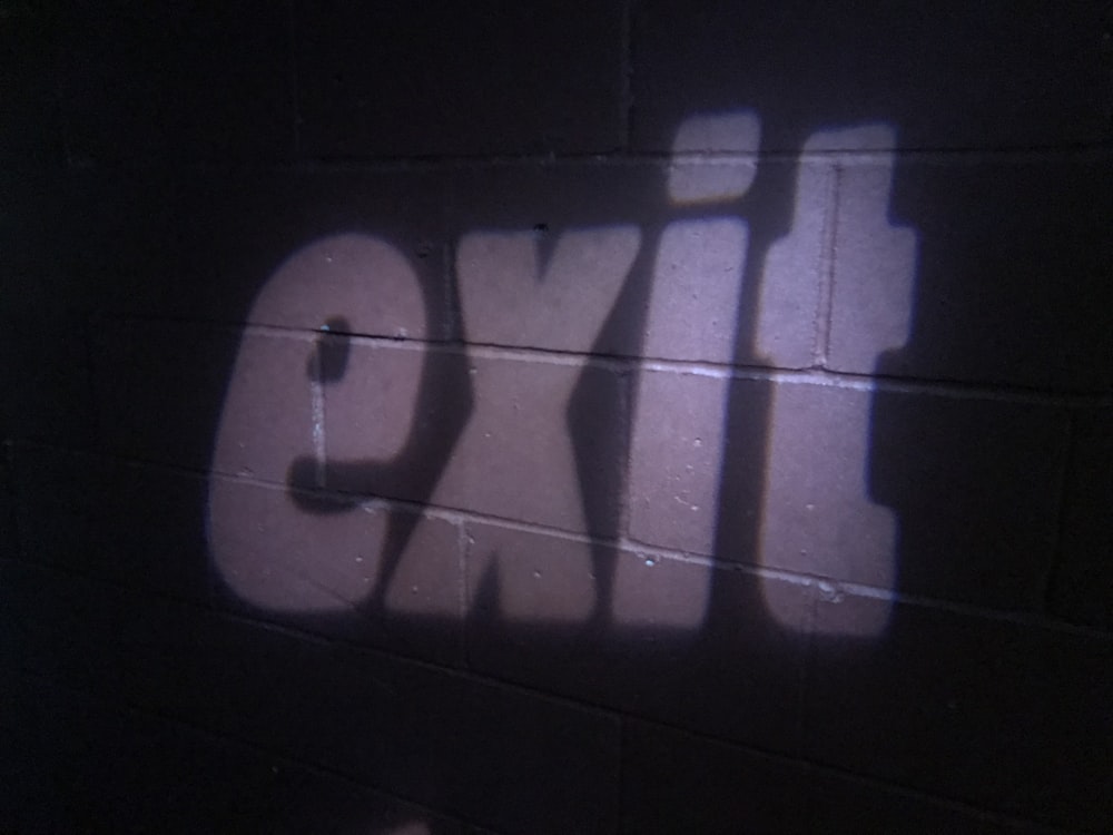 the shadow of a person standing in front of a brick wall