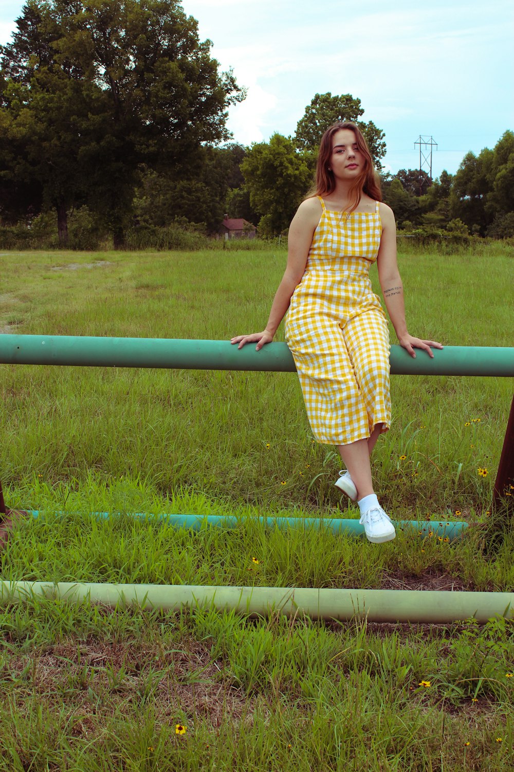 woman wearing red dress sitting on the fence