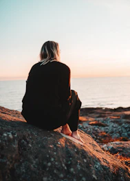 women sitting in a rock during daytime
