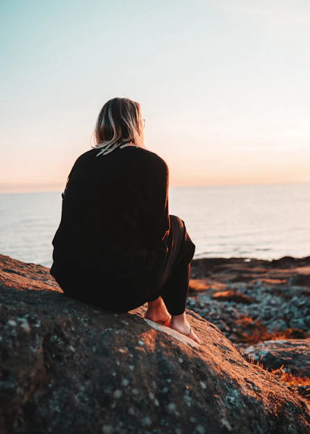 women sitting in a rock during daytime
