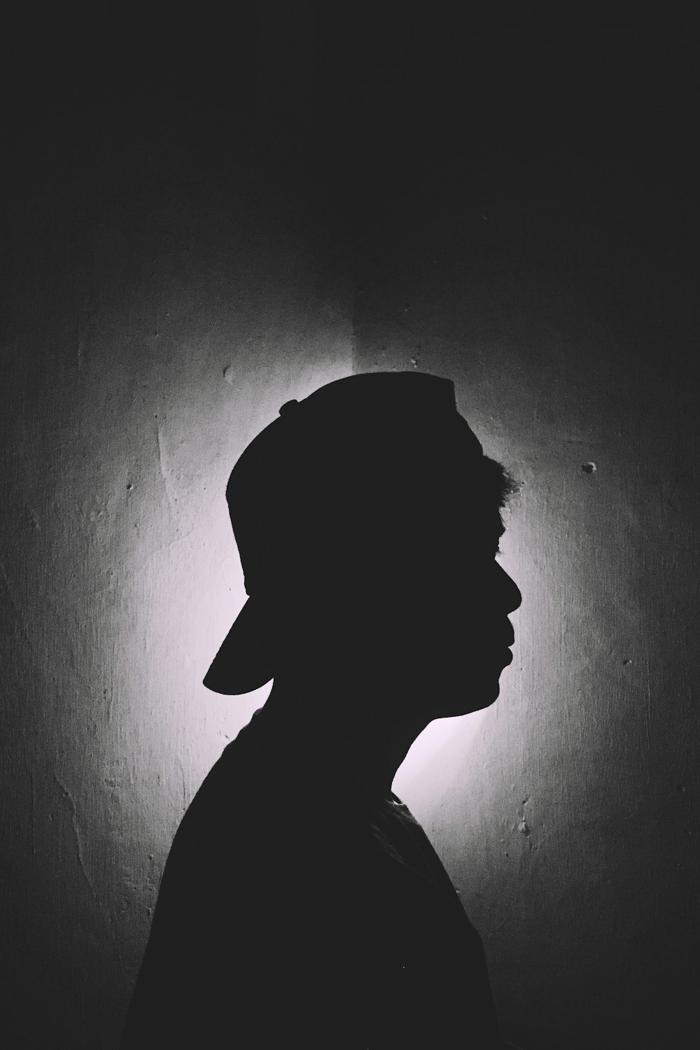 man wearing cap inside dark roomn