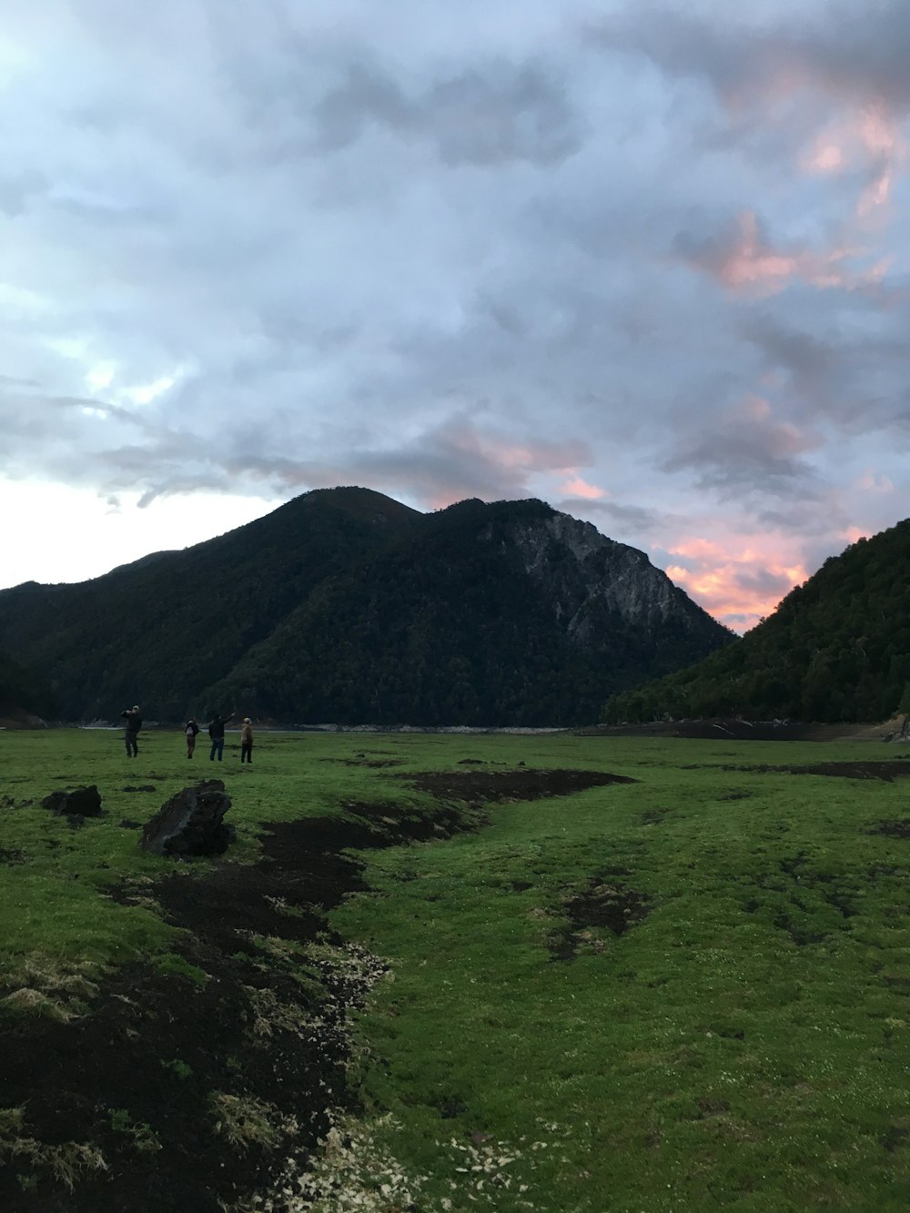 four person standing near mountain