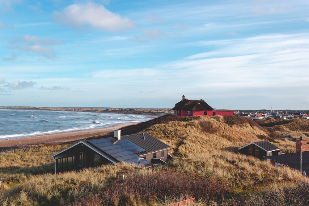 red house near sea at daytime