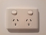 Close-up of modern electrical switches and outlets mounted on a wall.