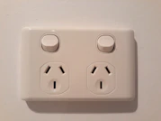 Close-up of modern electrical switches and outlets mounted on a wall.