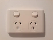 Close-up of modern electrical switches and outlets mounted on a wall.
