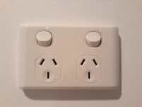 Detailed view of electrical switches and outlets installed on a clean white wall.
