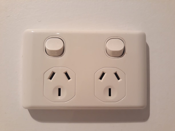 Close-up of a sleek, modern electrical outlet installed on a bright wall.