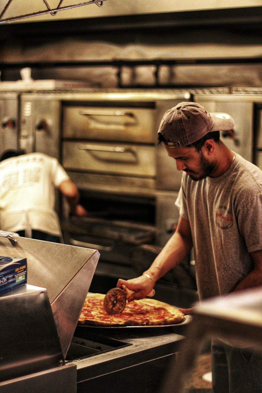 homme trancher la pizza