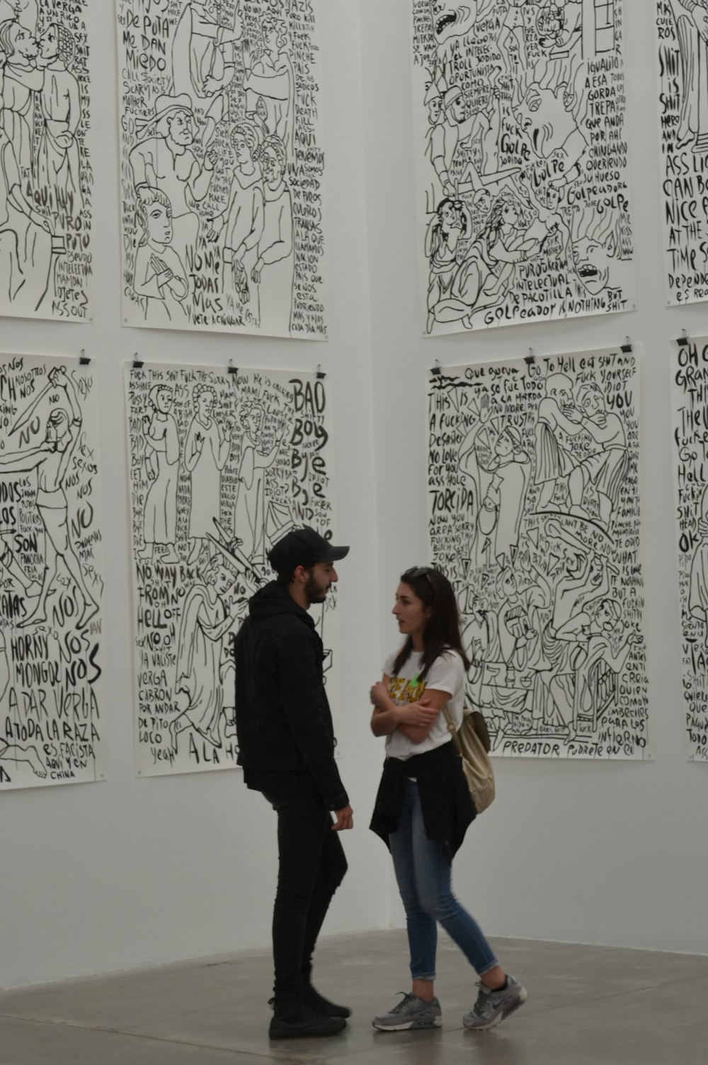 man wearing black cap talking to woman