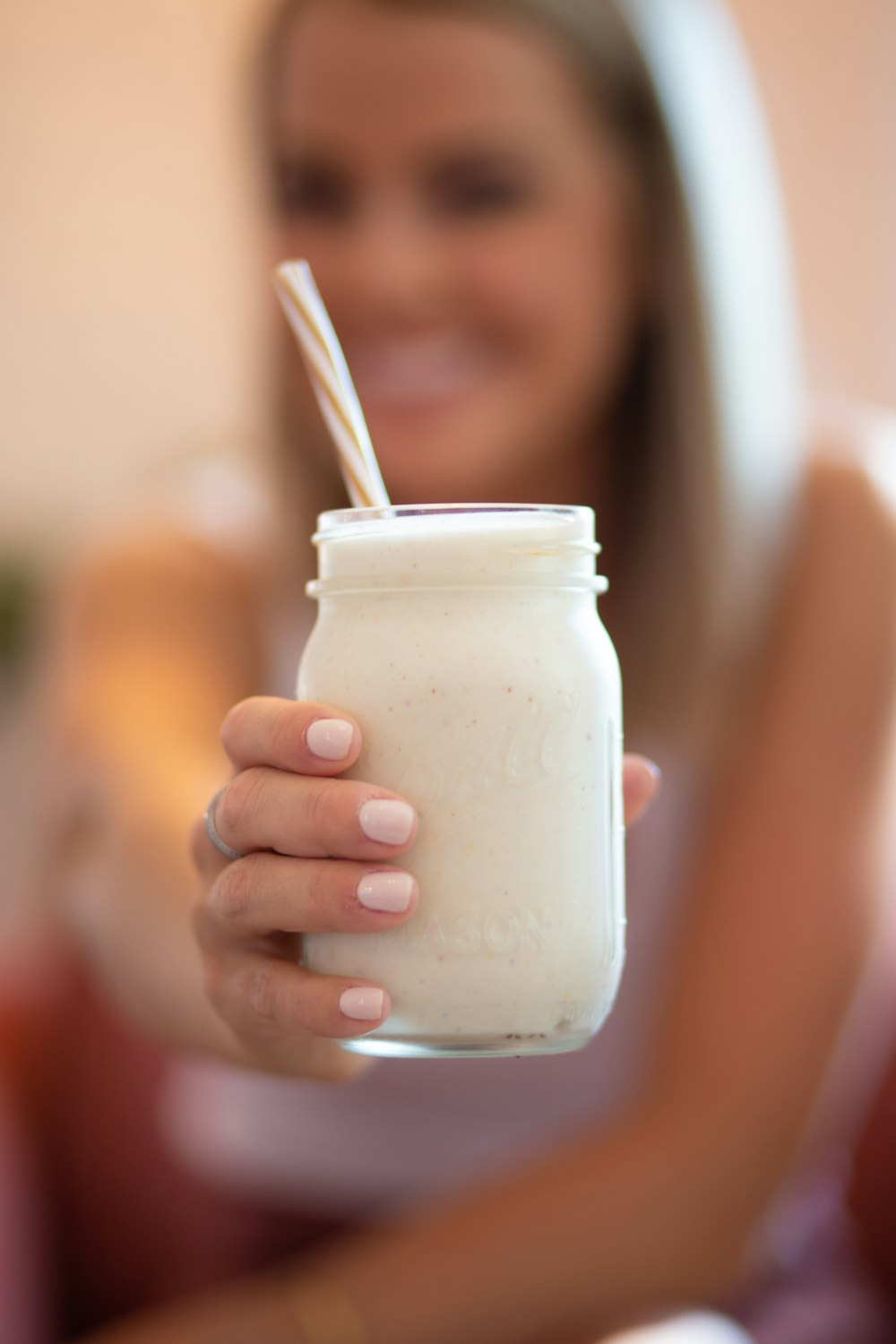 mujer sosteniendo un frasco de vidrio