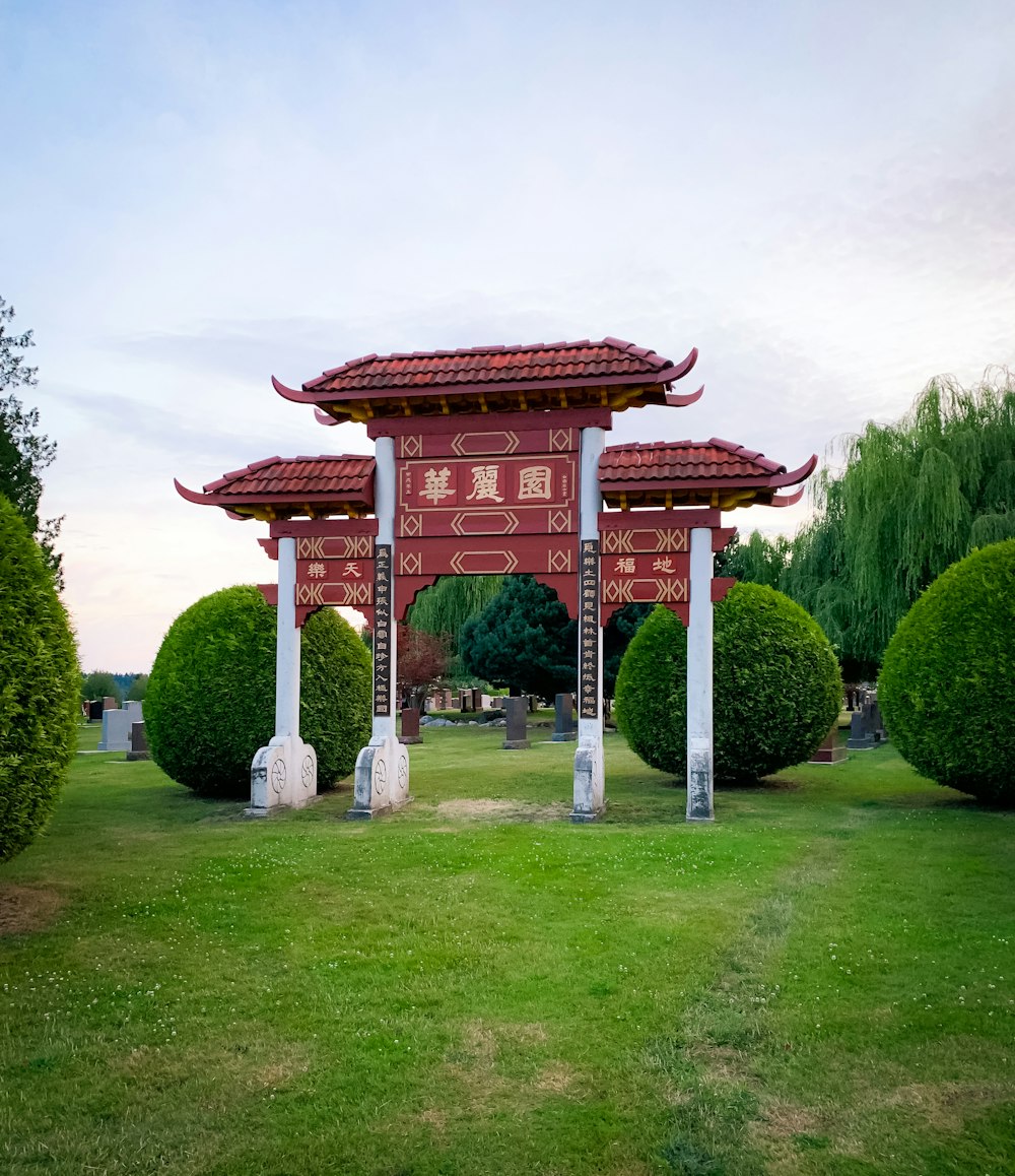 maroon and white arch and grass field scenery