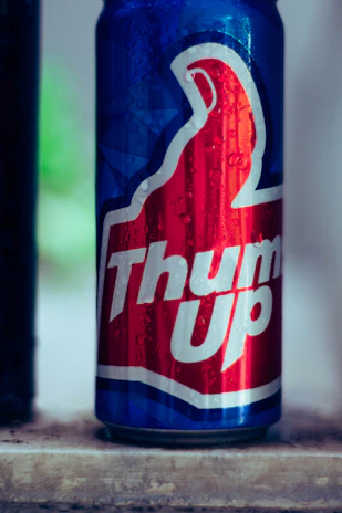 Close-up of a cold, frosty beverage can with subtle neon red glow in the background.