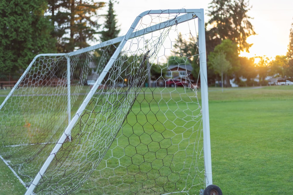 black soccer goal net on field of grass