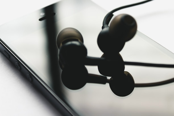 Close-up of a smartphone and headphones purchased from Sham Sharif Bazar on a wooden table.