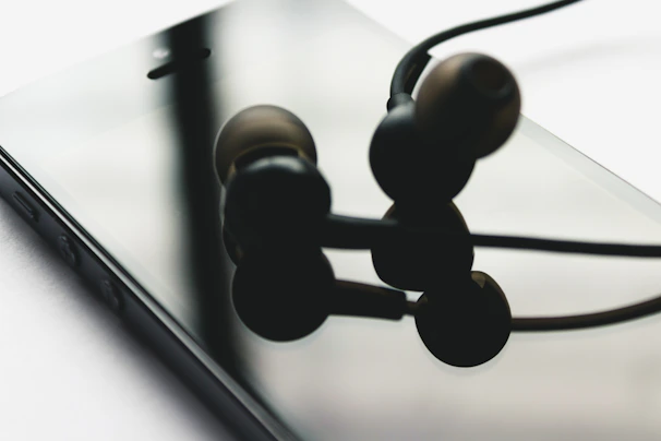 Close-up of a hand adding a stylish pair of headphones to an online wishlist on a smartphone