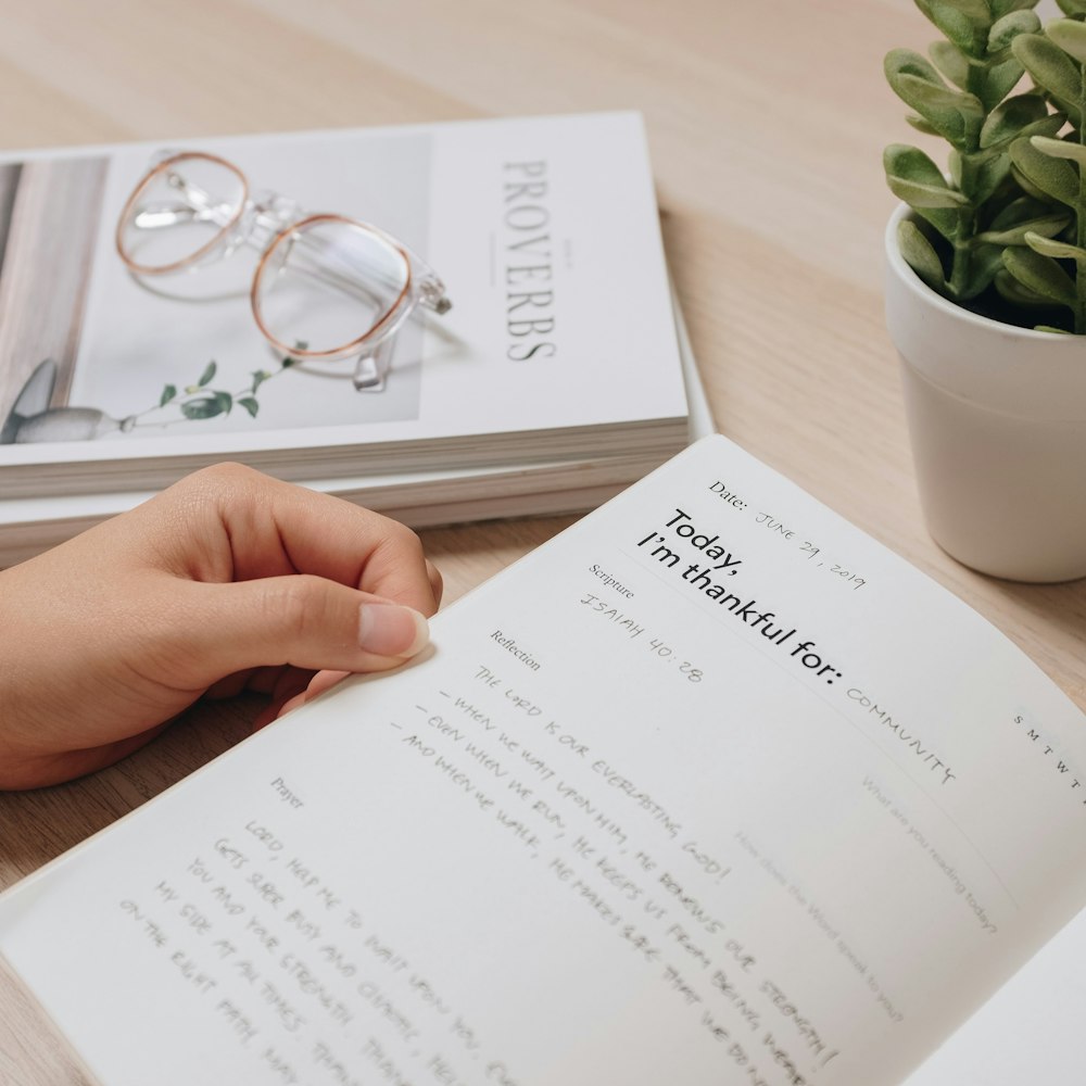 a person is reading a book on a table