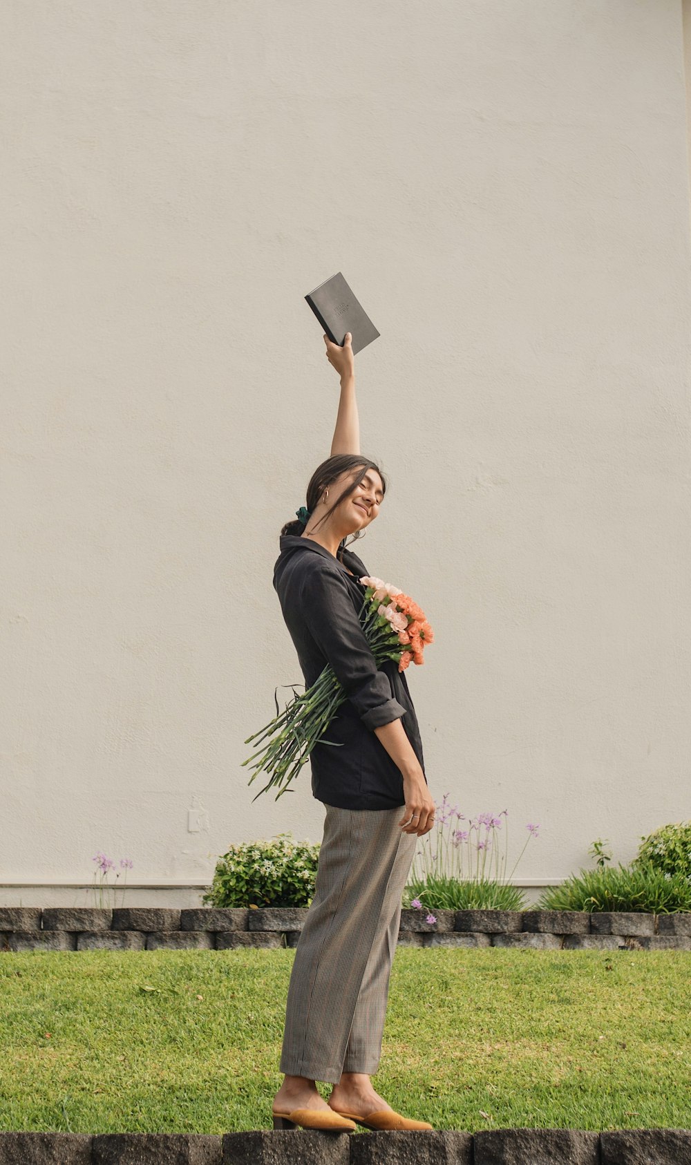 woman raising hand holding book