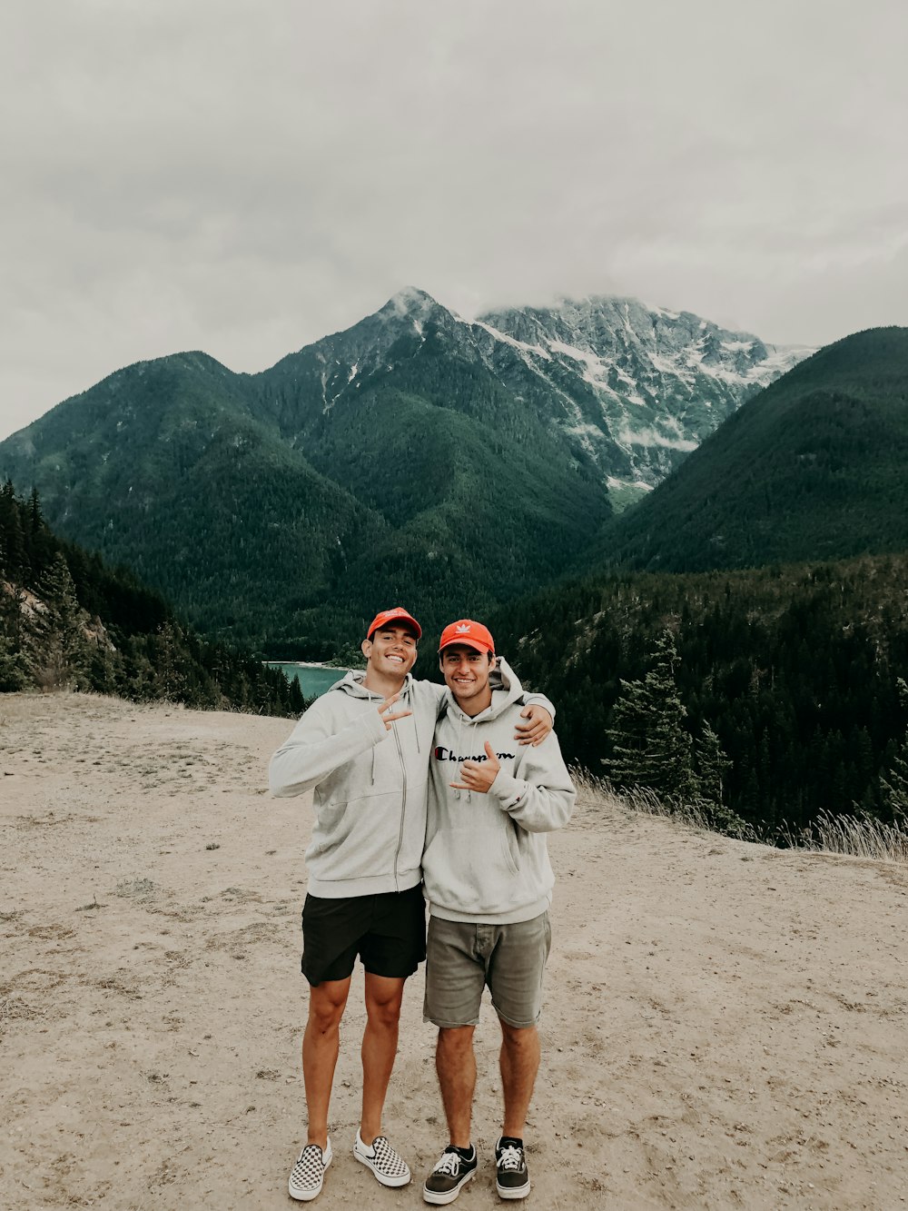 two men in gray hoodies under white clouds