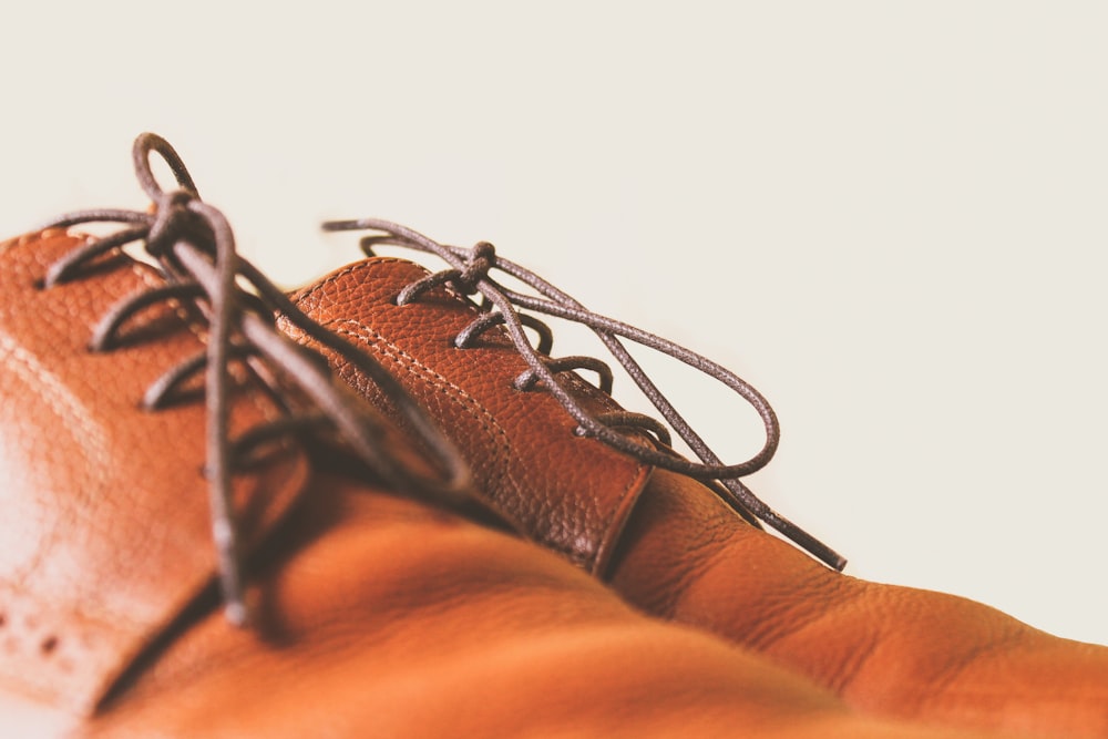closeup photo of brown leather lace-up shoes