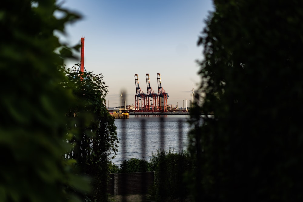 three red tower cranes under blue sky