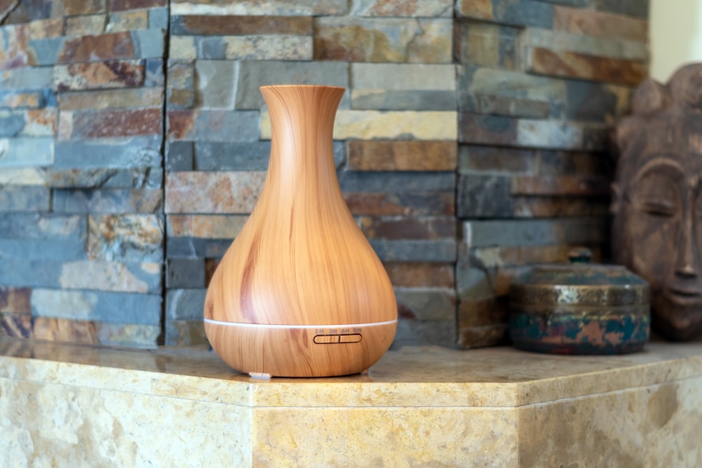 a wooden vase sitting on top of a stone counter