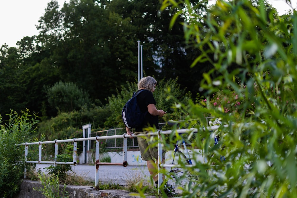 man wearing black T-shirt carrying backpack