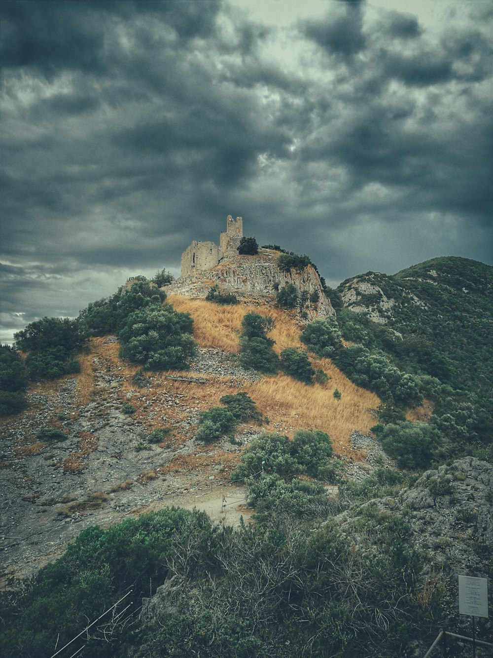 曇り空の下の丘の上に座っている城