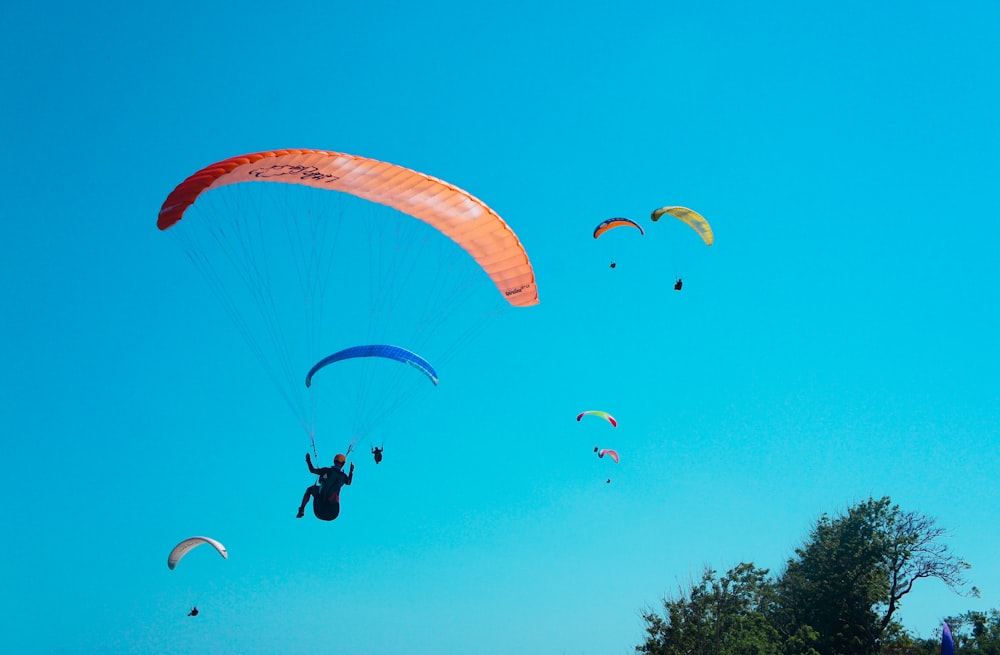 person gliding with orange glider