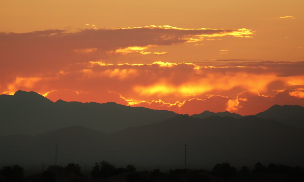 the sun is setting over a mountain range