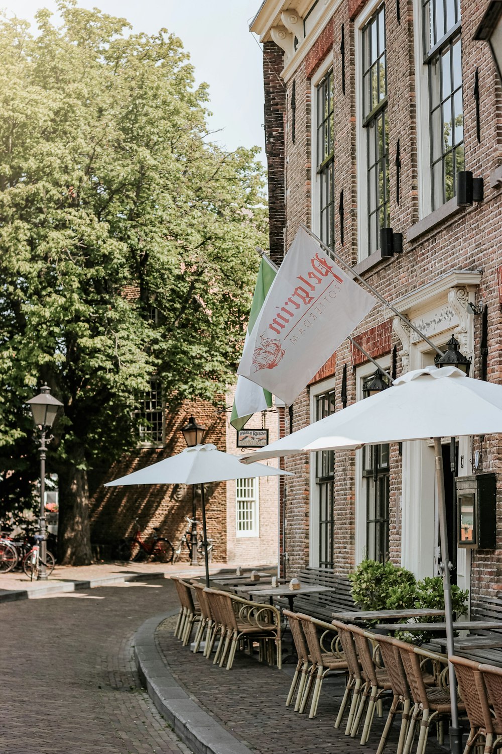 white flag besides bistro chairs during daytime