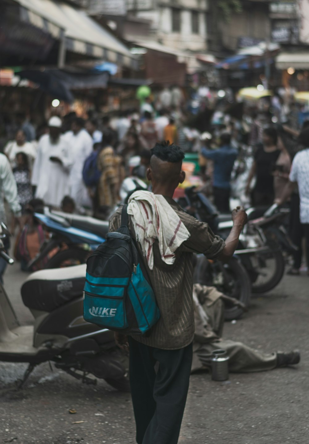 man carrying blue and teal backpack