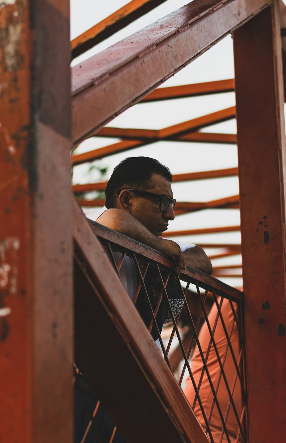 man standing near orange railings