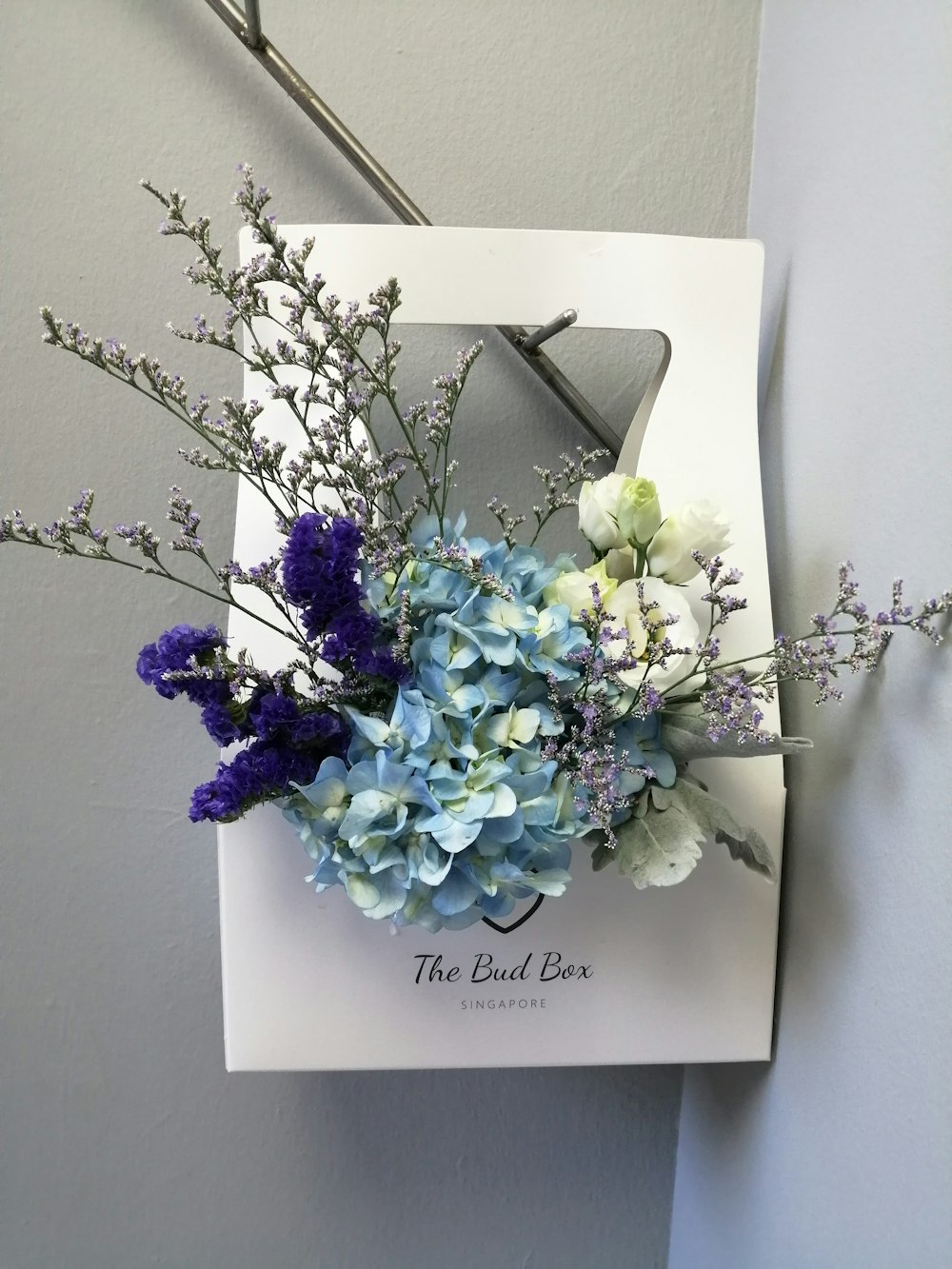 a bouquet of blue and white flowers in a white box