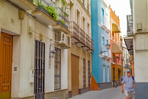 A traveler walking along a vibrant city street filled with colorful buildings and local shops.