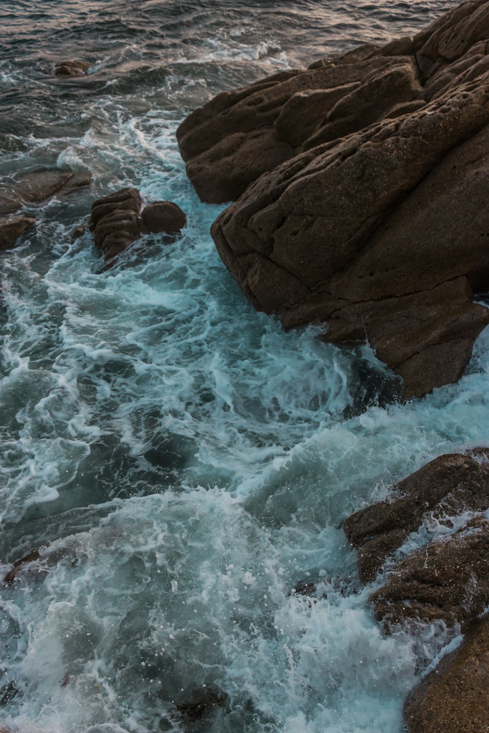 black rock on body of water