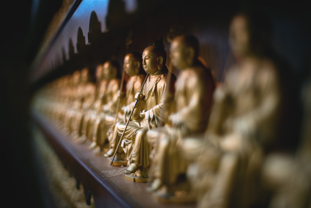 selective focus gold buddha sitting statue on the wall