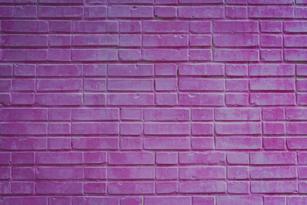 a pink brick wall with a red stop sign on it