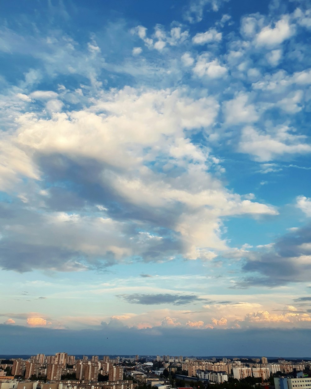 cityscape under blue and white clouds