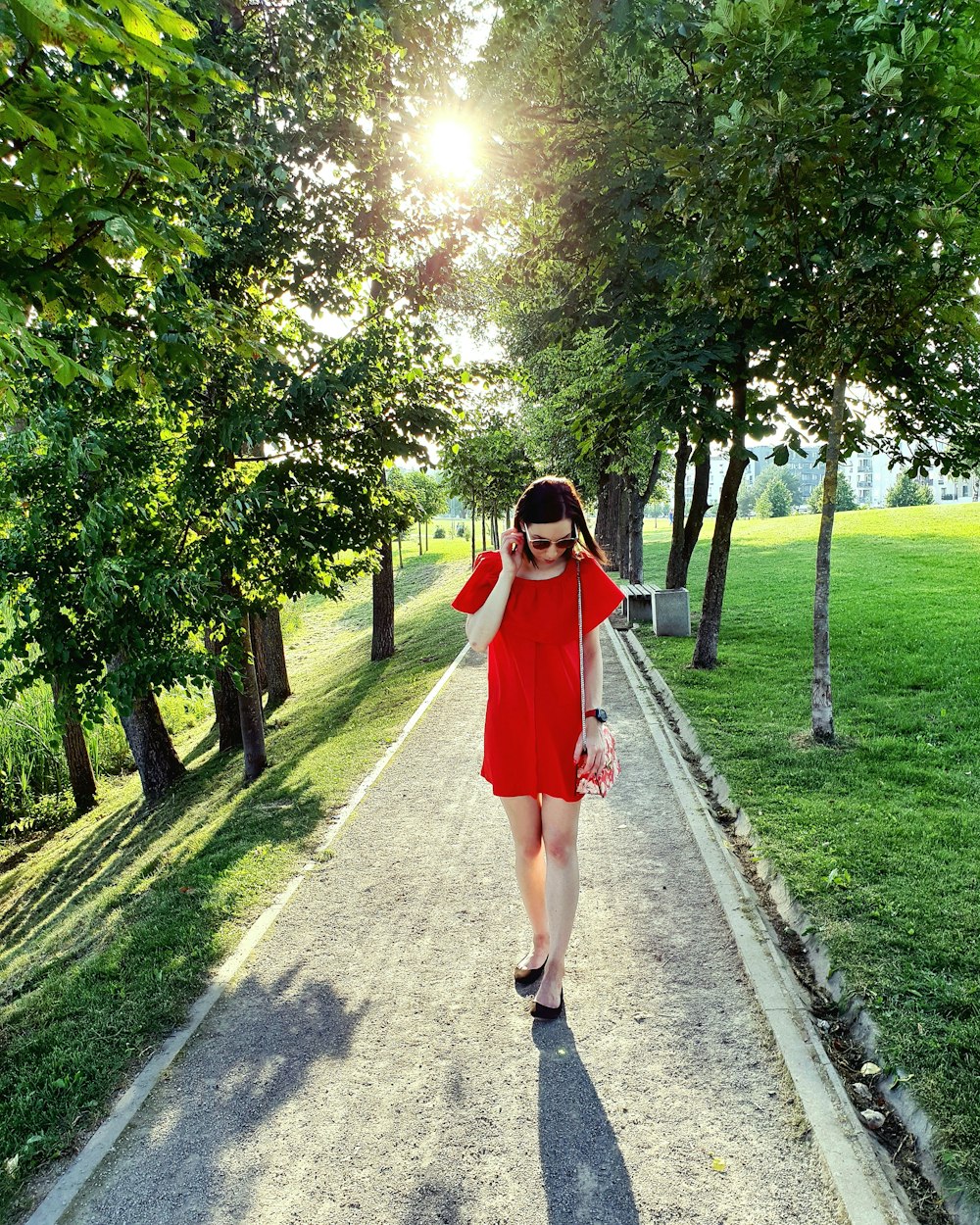 woman in red dress standing on footpath