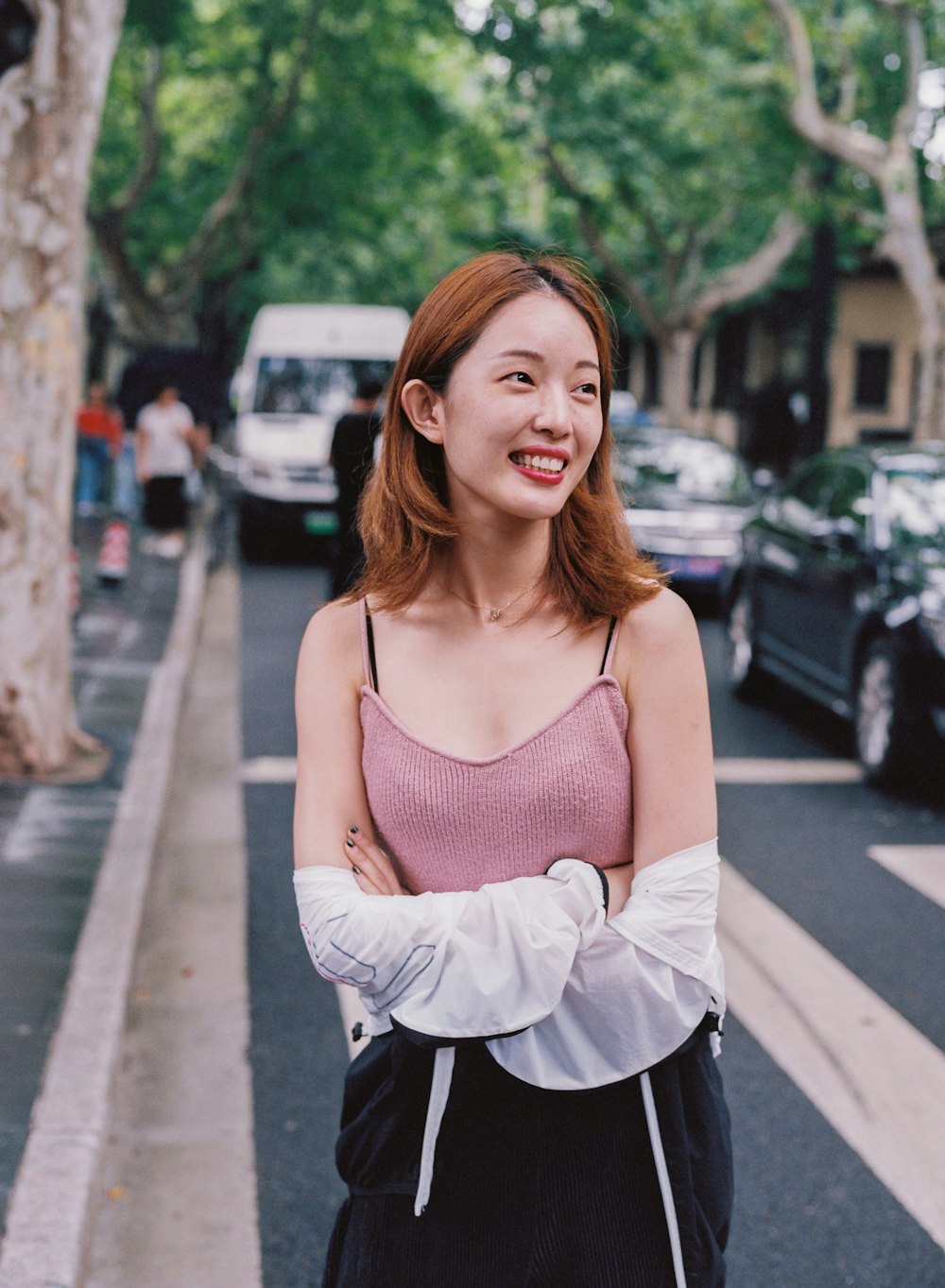 woman standing and laughing surrounded with vehicles