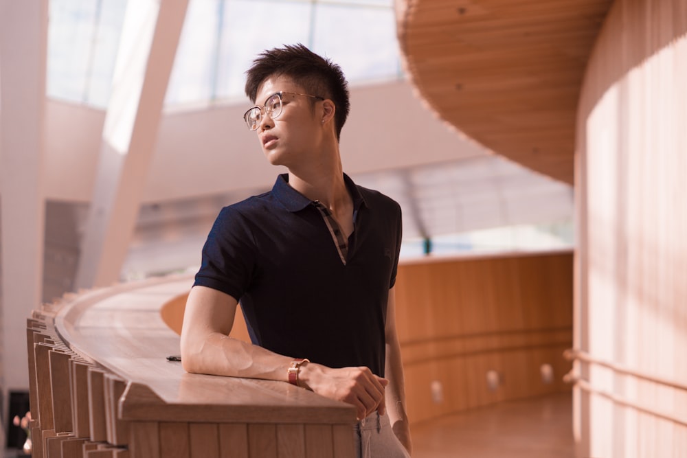 man wearing black polo shirt standing and glancing his right side