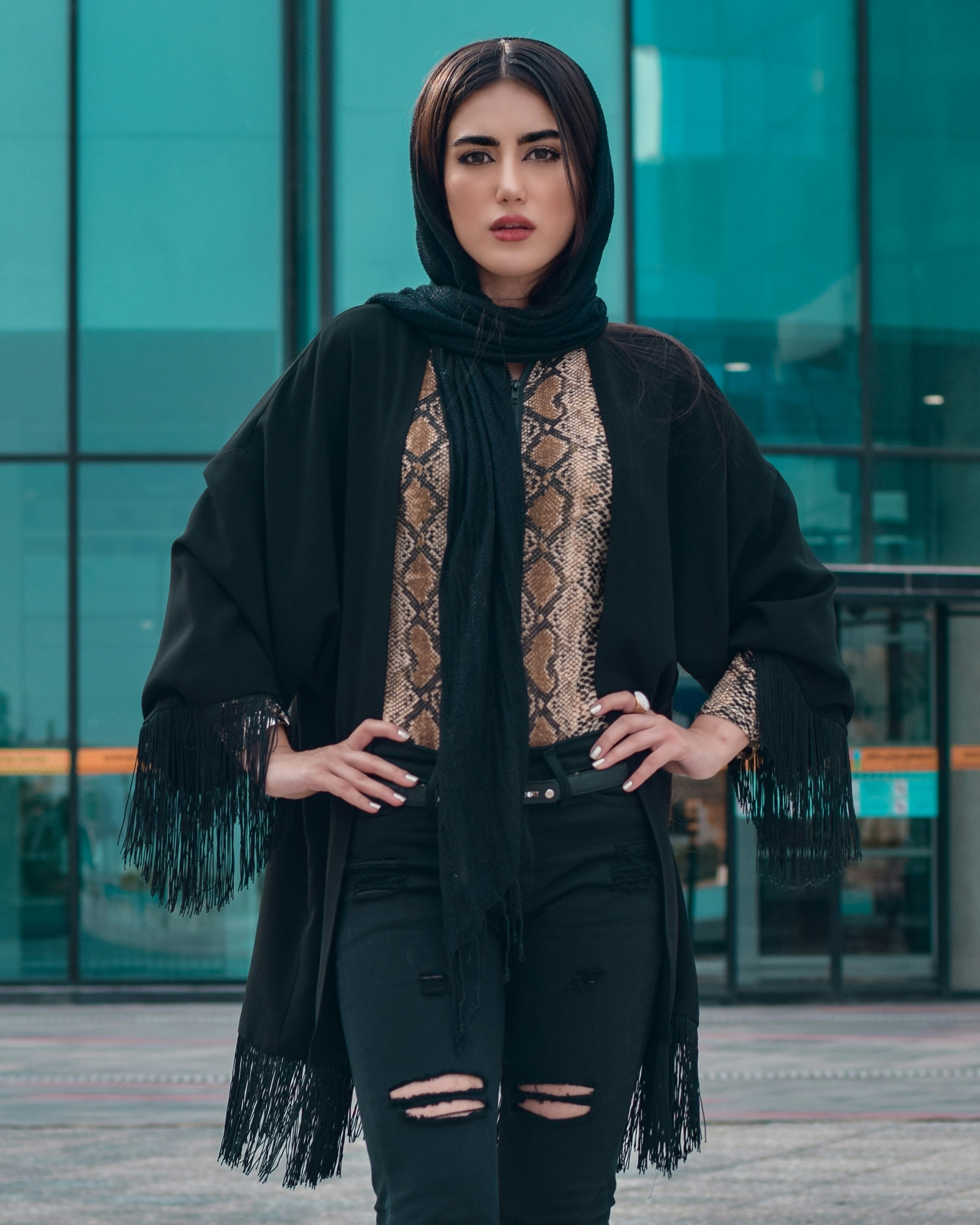 woman wearing black coat and scarf in both hand akimbo