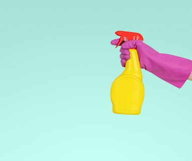 person holding yellow plastic spray bottle